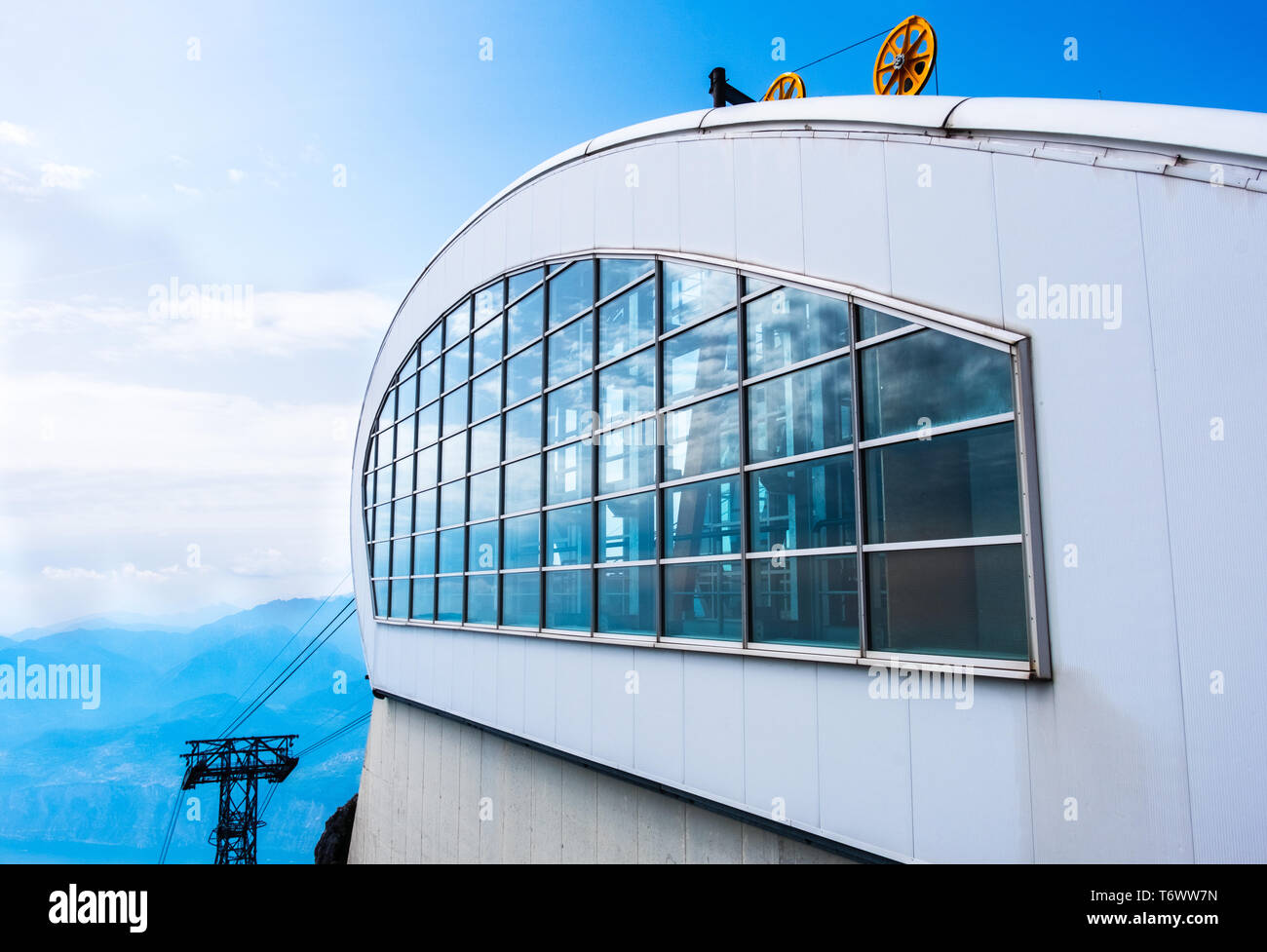 modern aerial lift cable car skiing station arrival on high scenic panoramic blue sky mountain top . Stock Photo