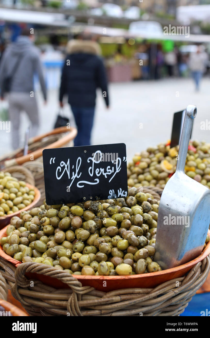 Vente d'olives vertes, ail et persil, sur un marché local. Stock Photo