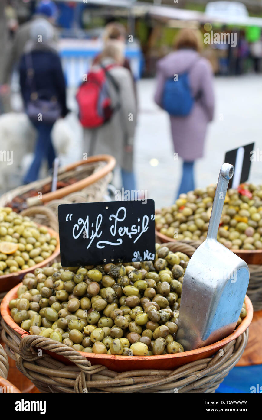 Vente d'olives vertes, ail et persil, sur un marché local. Stock Photo