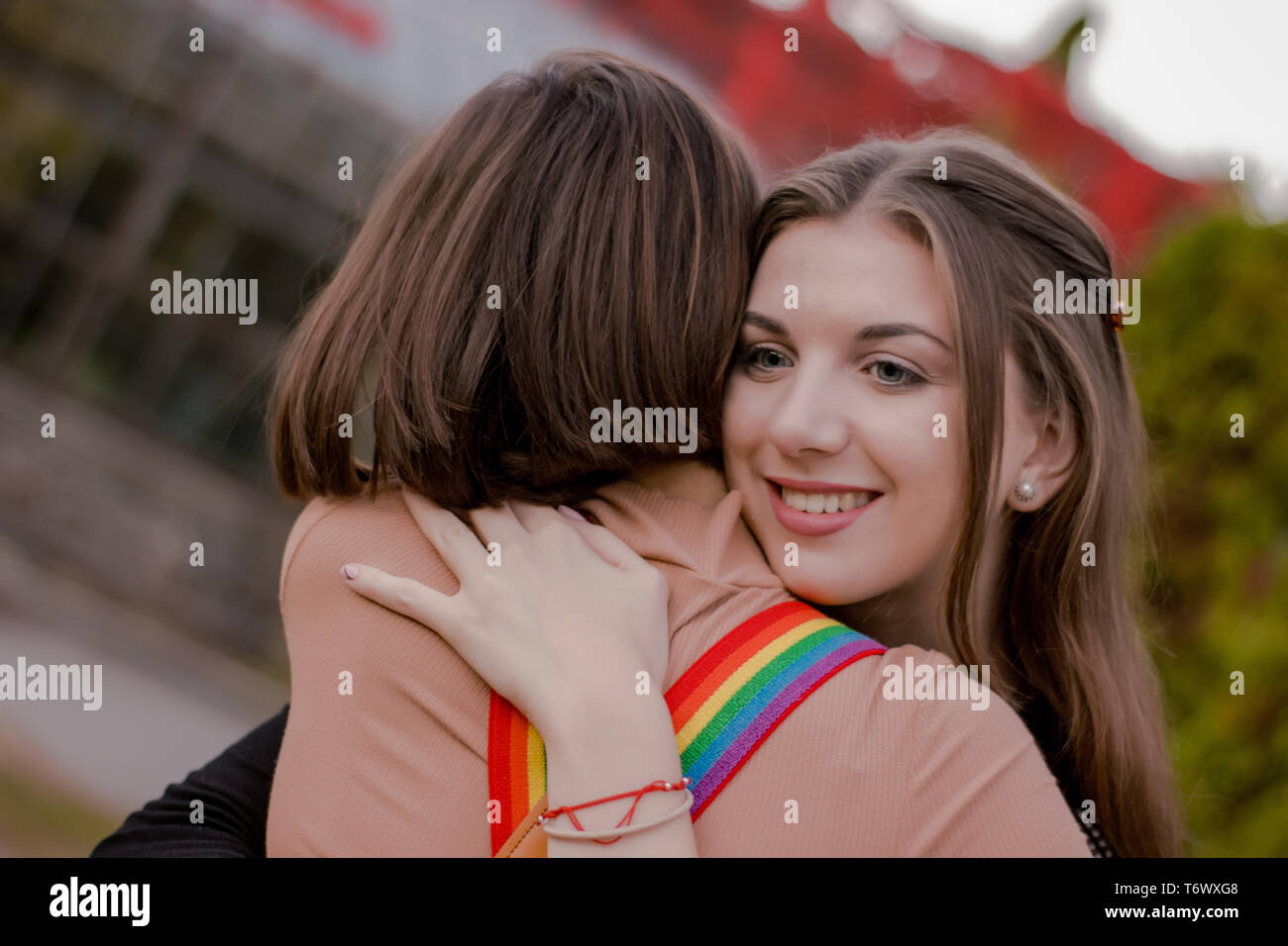 Smiling happy girl hugs his girlfriend tightly Stock Photo