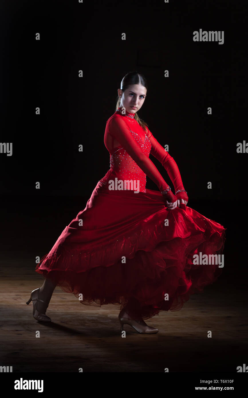 bailando red dress Beautiful young hispanic flamenco dancer in red dress isolated on black  background Stock Photo