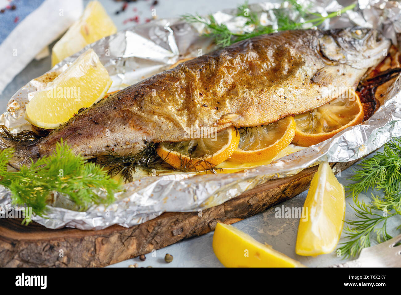Baked lake trout with lemon slices. Stock Photo