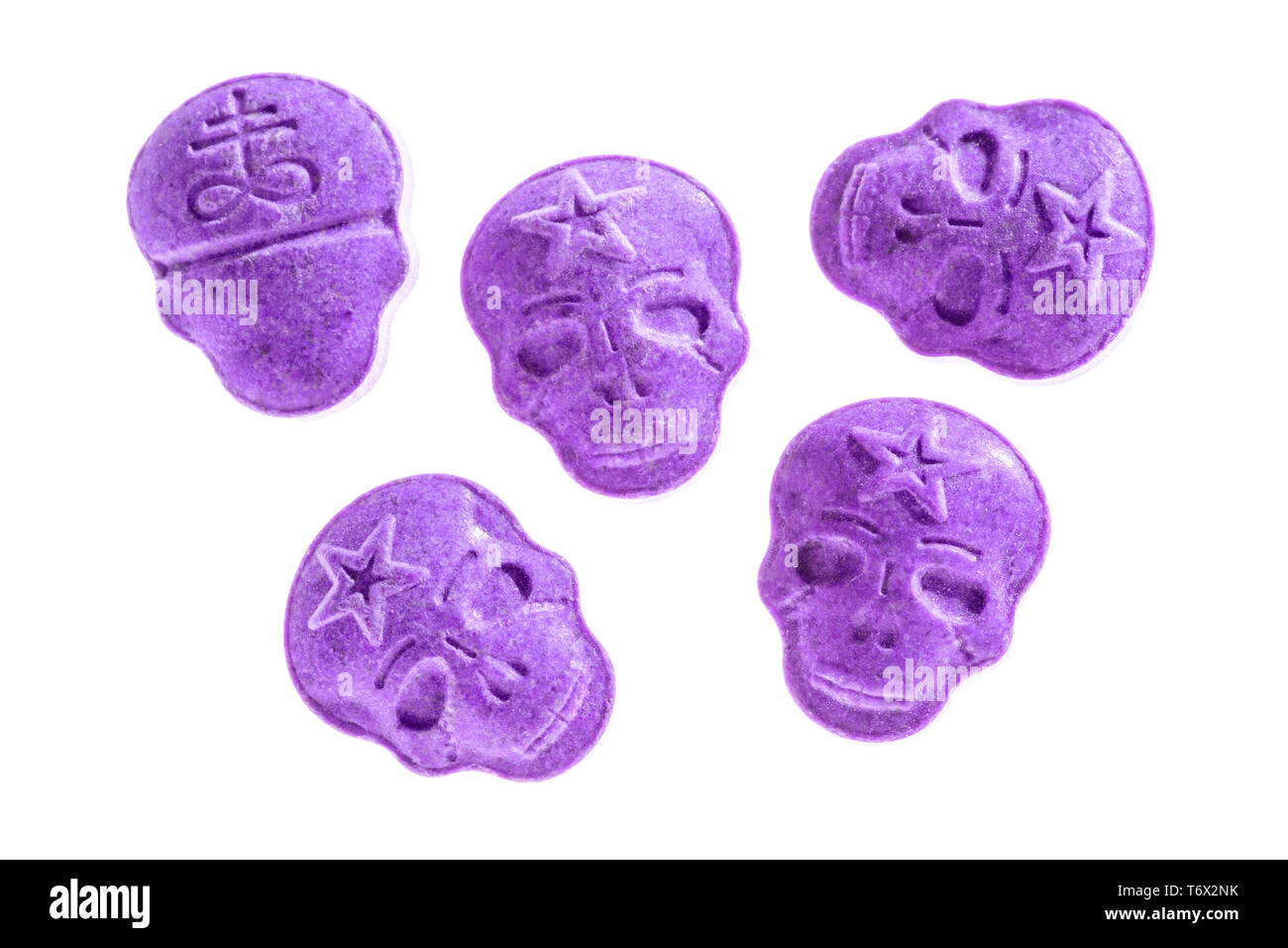 Five purple Army Skull, Ecstasy, MDMA, Amphetamine or medication pills shaped like a skull isolated on a white background. Stock Photo