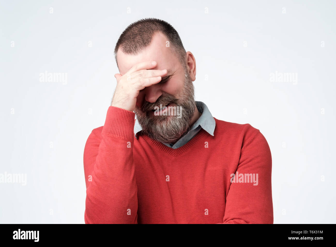 Mature man making facepalm gesture, covering eyes. Stock Photo