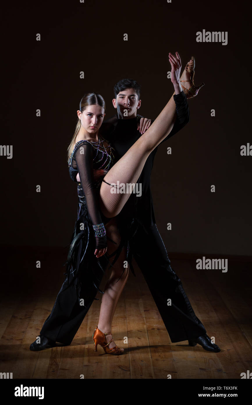 Beautiful young dancers in ballroom isolated on black background, couple dance Stock Photo