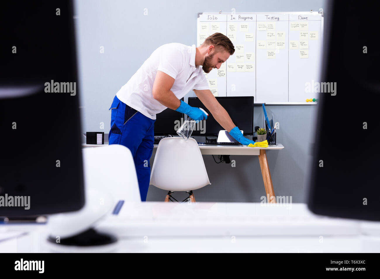 Janitor cleaning white desk in modern office Stock Photo Alamy