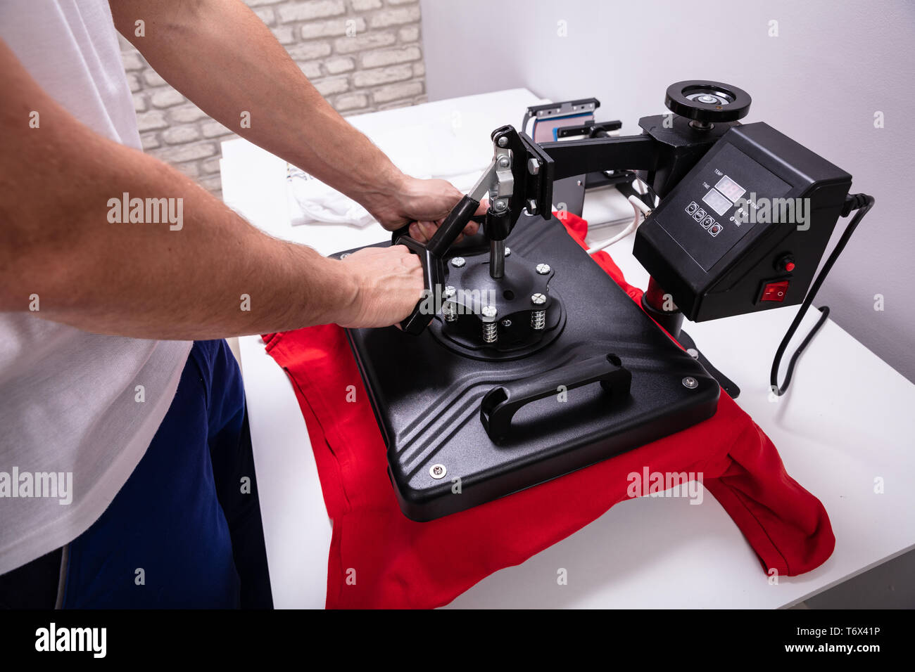 Man printing on t shirt in workshop Stock Photo