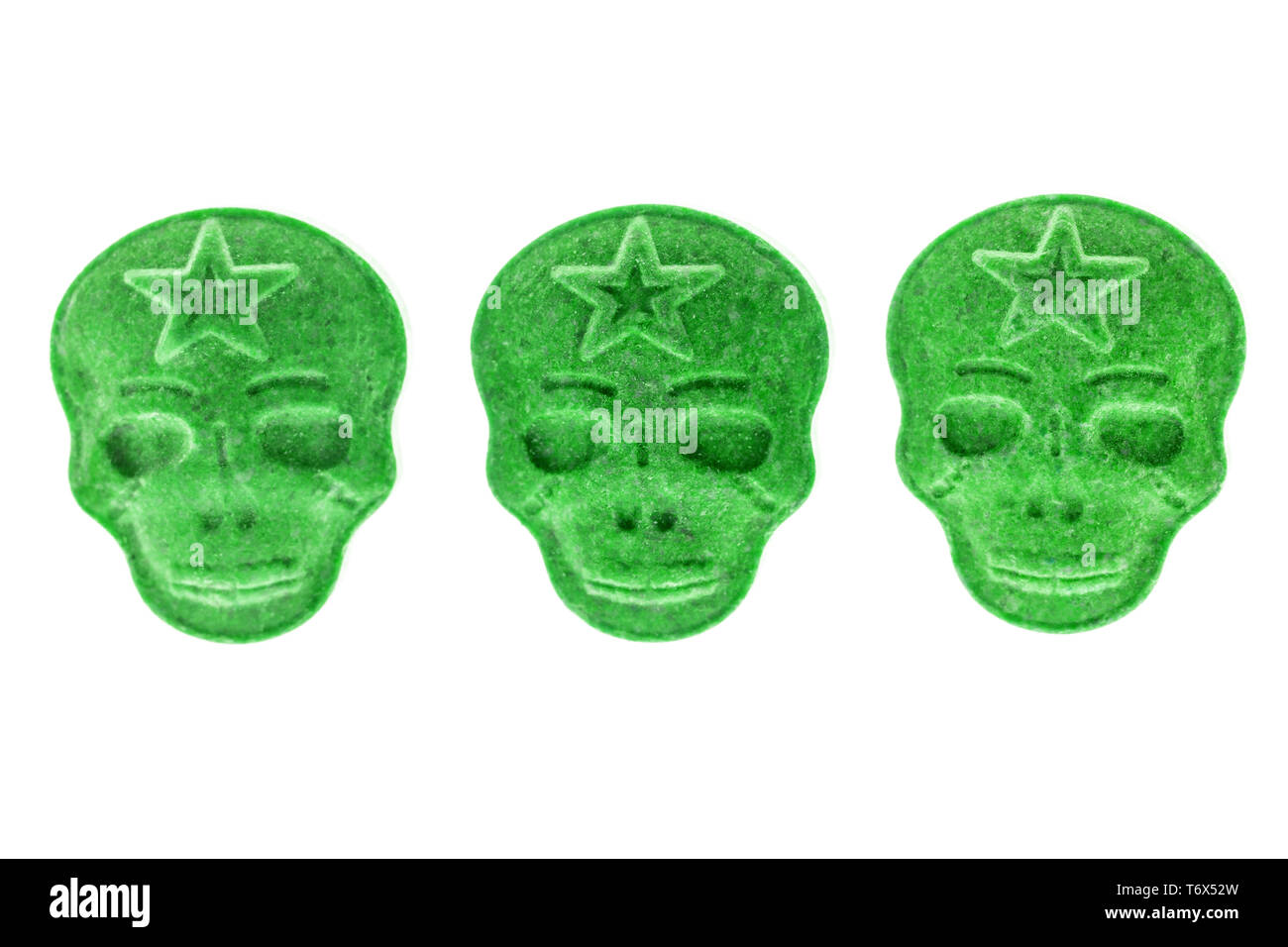 Three Green army Skull, Ecstasy, MDMA, Amphetamine or medication pills shaped like a skull isolated on a white background. Stock Photo