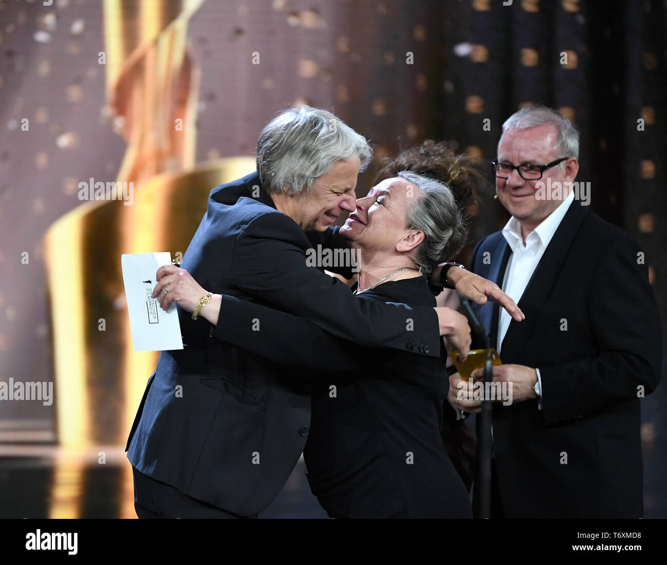 Berlin, Germany. 03rd May, 2019. Director Andreas Dresen (l, film 'Gundermann') is awarded the 69th German Film Prize 'Lola' in the category 'Best Director' by Ursula Werner (M), backed by Joachim Krol (r). Credit: Britta Pedersen/dpa-Zentralbild/dpa/Alamy Live News Stock Photo