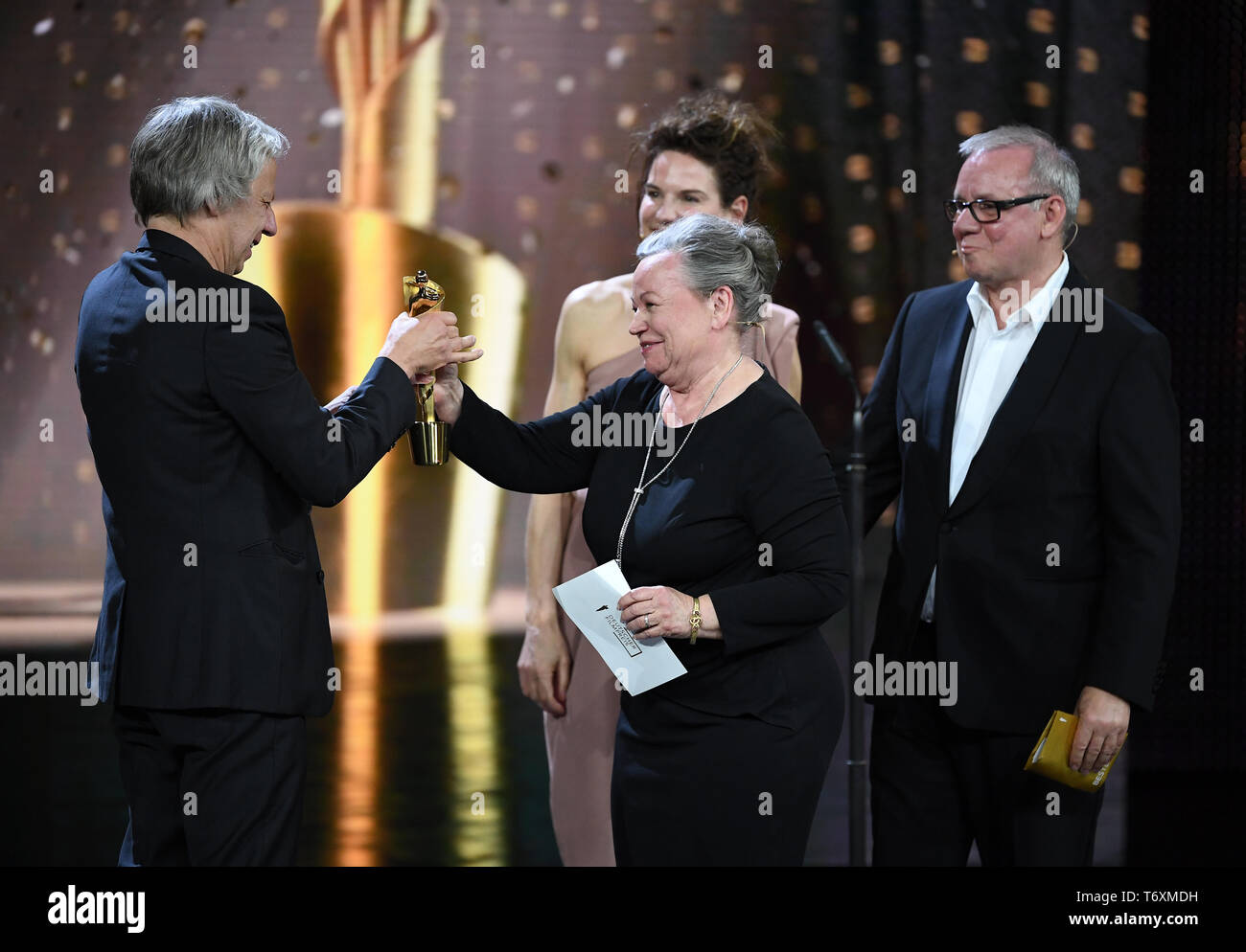 Berlin, Germany. 03rd May, 2019. Director Andreas Dresen (l, film 'Gundermann') receives the award in the category 'Best Director' from Ursula Werner (2nd from left) at the 69th German Film Award 'Lola'. Behind him are Bibiana Beglau and Joachim Krol (r). Credit: Britta Pedersen/dpa-Zentralbild/dpa/Alamy Live News Stock Photo
