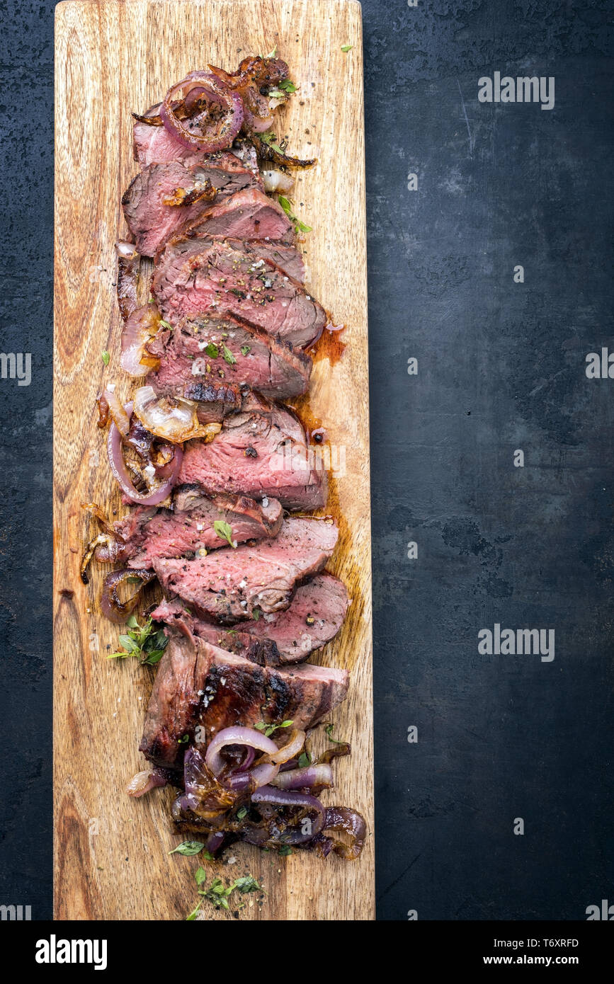 Traditional barbecue dry aged sliced roast beef with fried onion rings