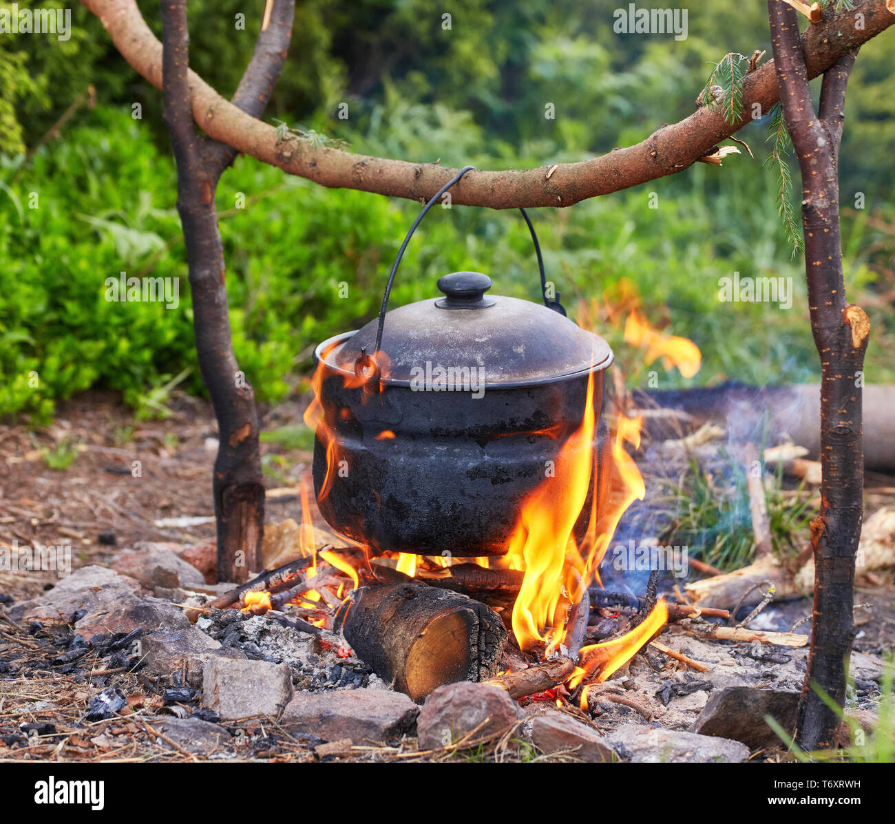 https://c8.alamy.com/comp/T6XRWH/old-small-kettle-is-heated-on-a-bonfire-on-a-green-mountain-meadow-during-a-bad-weather-epic-travel-in-the-mountains-T6XRWH.jpg