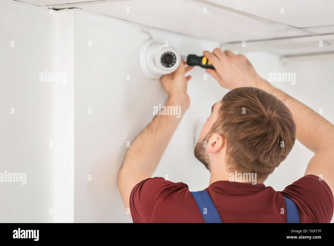 Electrician installing security camera indoors Stock Photo Alamy