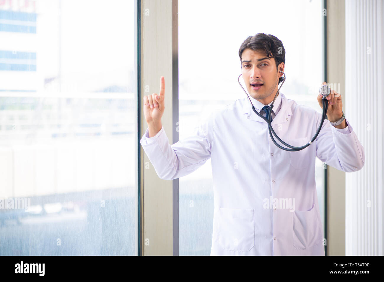 Handsome doctor listening young hi-res stock photography and images - Alamy