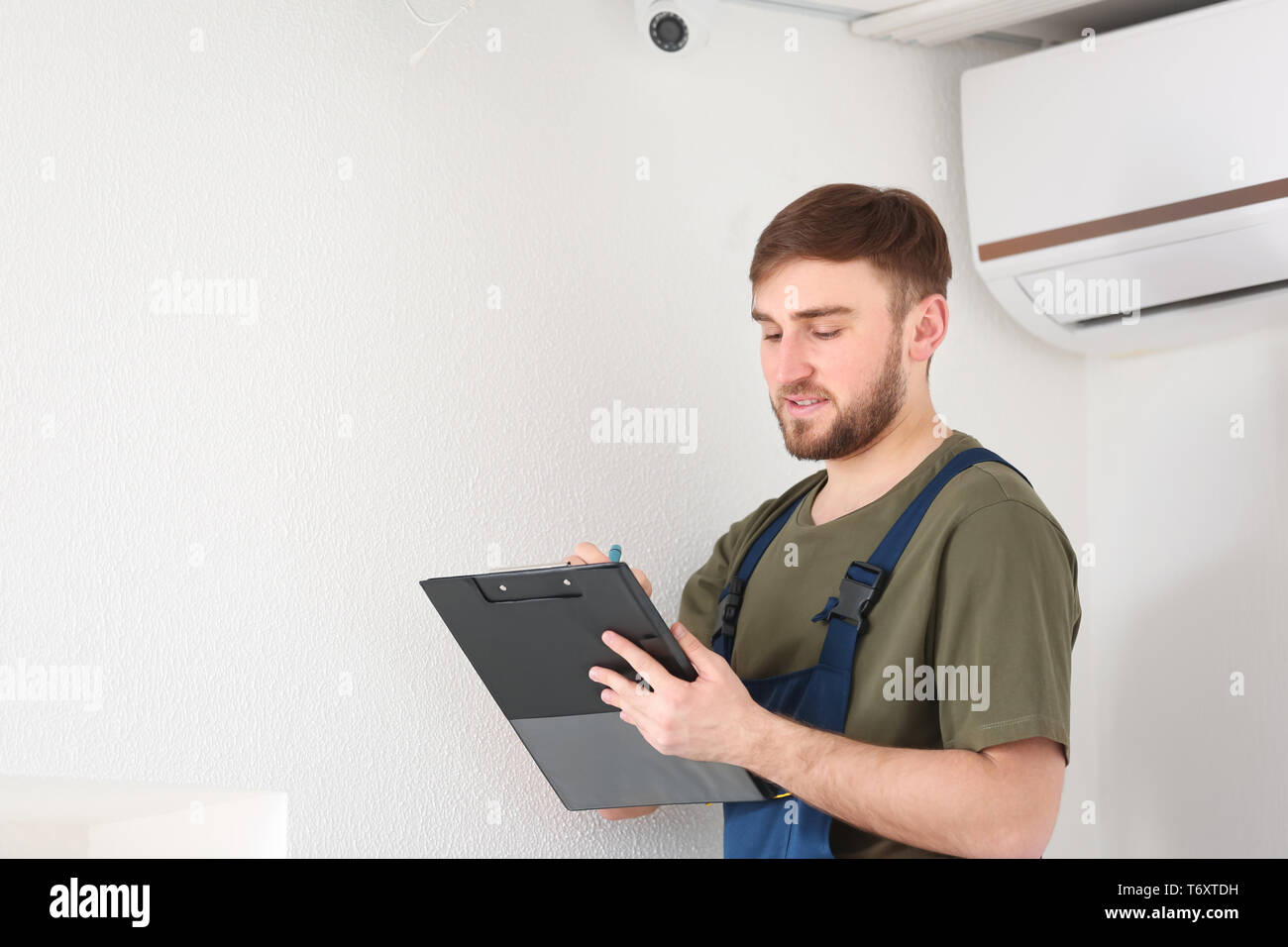 Electrician installing security camera indoors Stock Photo Alamy