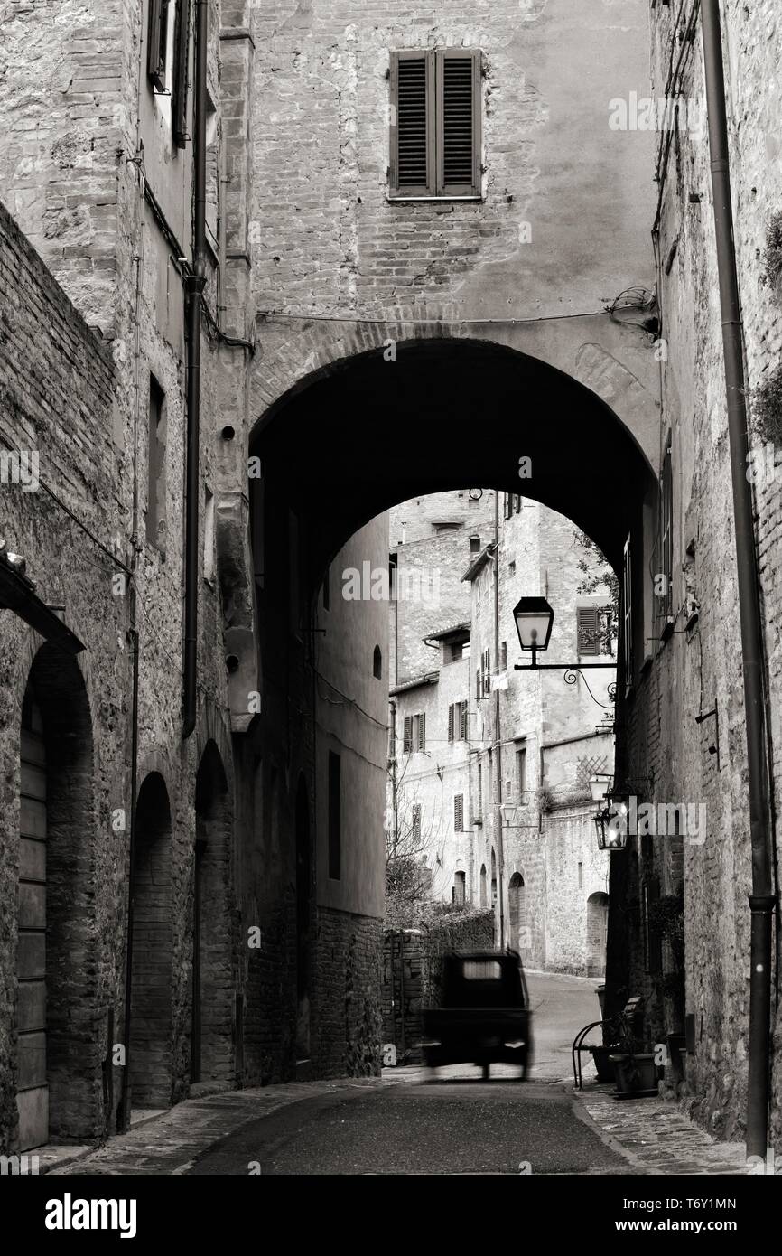 Tricycle, Ape drives through narrow lane in the old town, San Gimignano, Tuscany, Italy Stock Photo