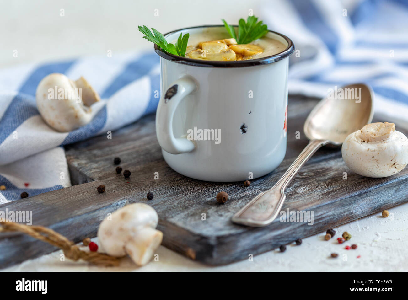 Homemade mushroom cream soup in an enamel mug. Stock Photo