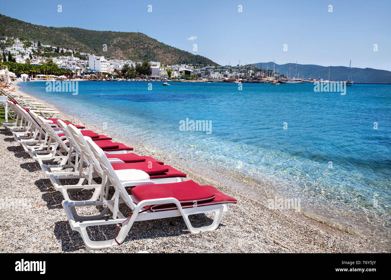 White sunbeds with red cover on the beach in Bodrum, Turkey Stock Photo