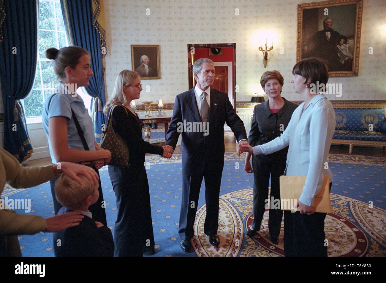 President George W Bush holds hands with family members of victims of United Flight 93 in the Blue Room of the White House, September 24, 2001. Courtesy National Archives. () Stock Photo