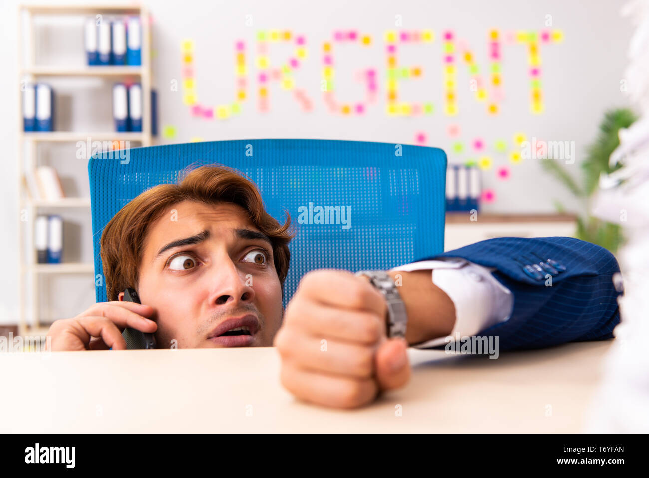 Young employee suffering from excessive work Stock Photo