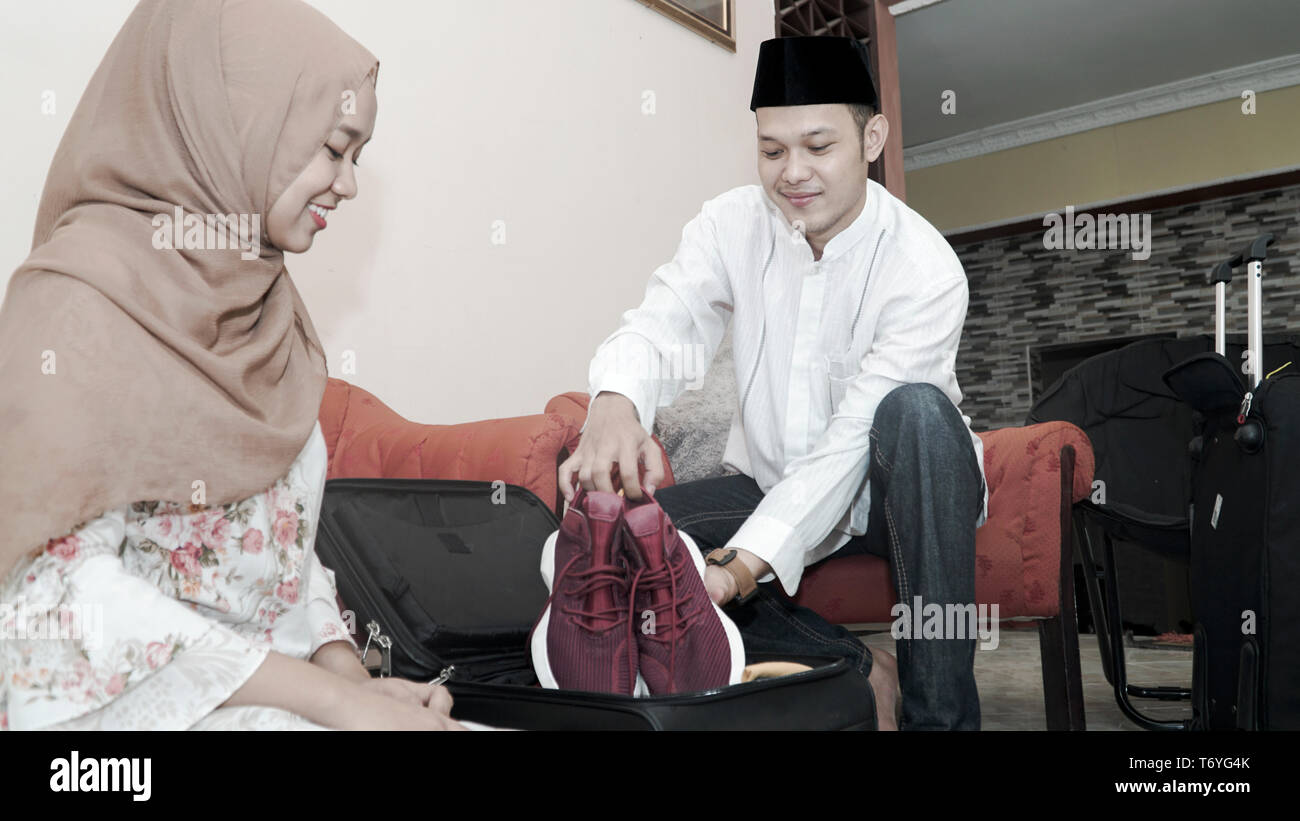 happy muslim couple man and woman put stuff in suitcase luggage prepare ...