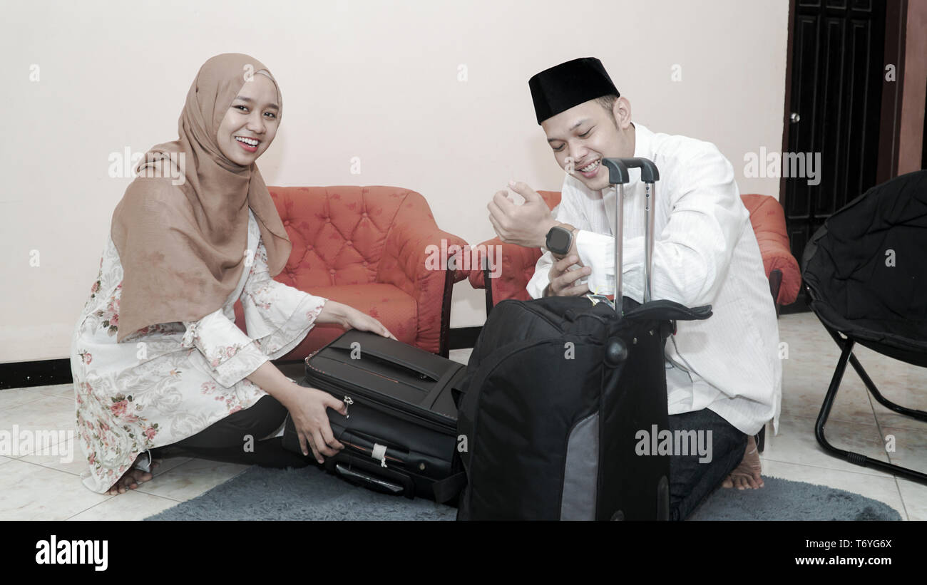 happy muslim couple man and woman put stuff in suitcase luggage prepare ...