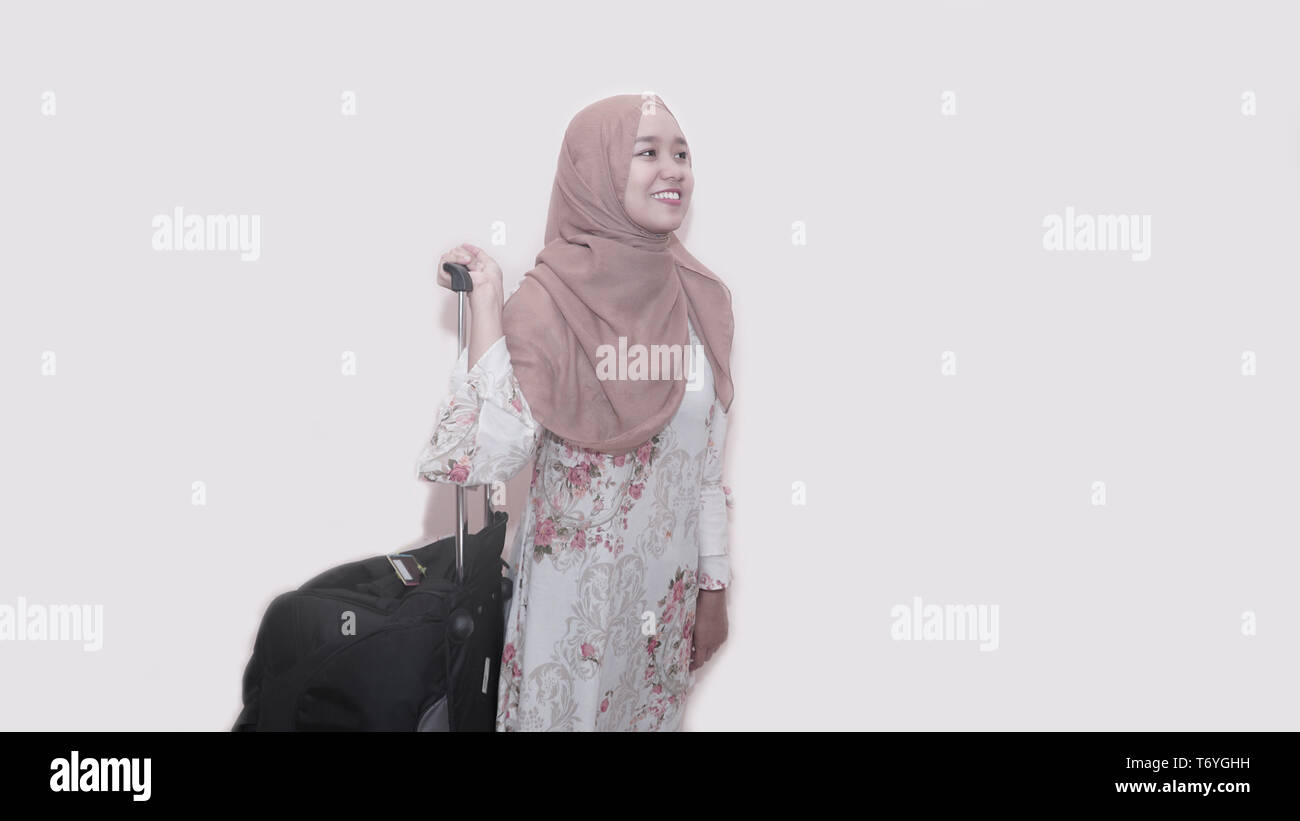 Portrait of asian muslim woman wearing head scarf or hijab holding black suitcase luggage get ready for traveling and trip Stock Photo