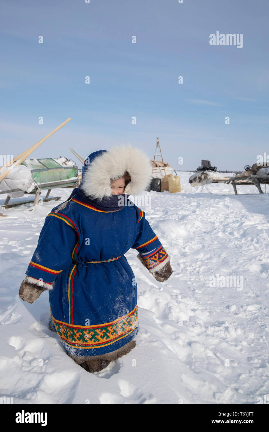 Russia, Yamal-Nenets Autonomous Region, Yamal peninsula. Nomadic Nenets reindeer herders camp, young child in traditional attire. Stock Photo