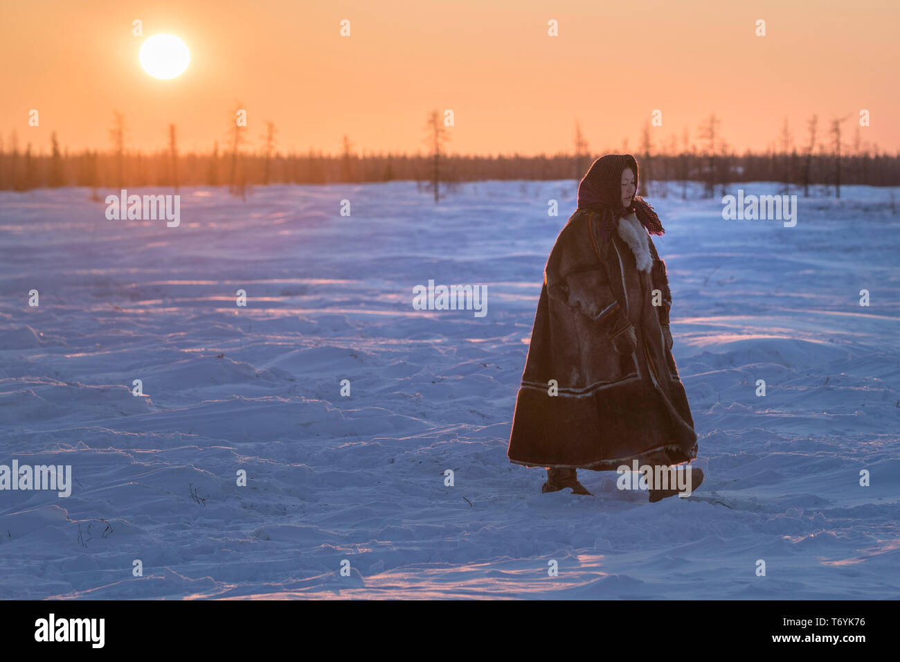 Russia, Yamal-Nenets Autonomous Region, Yamal peninsula. Nomadic Nenets reindeer herders at camp, woman in traditional attire. Stock Photo