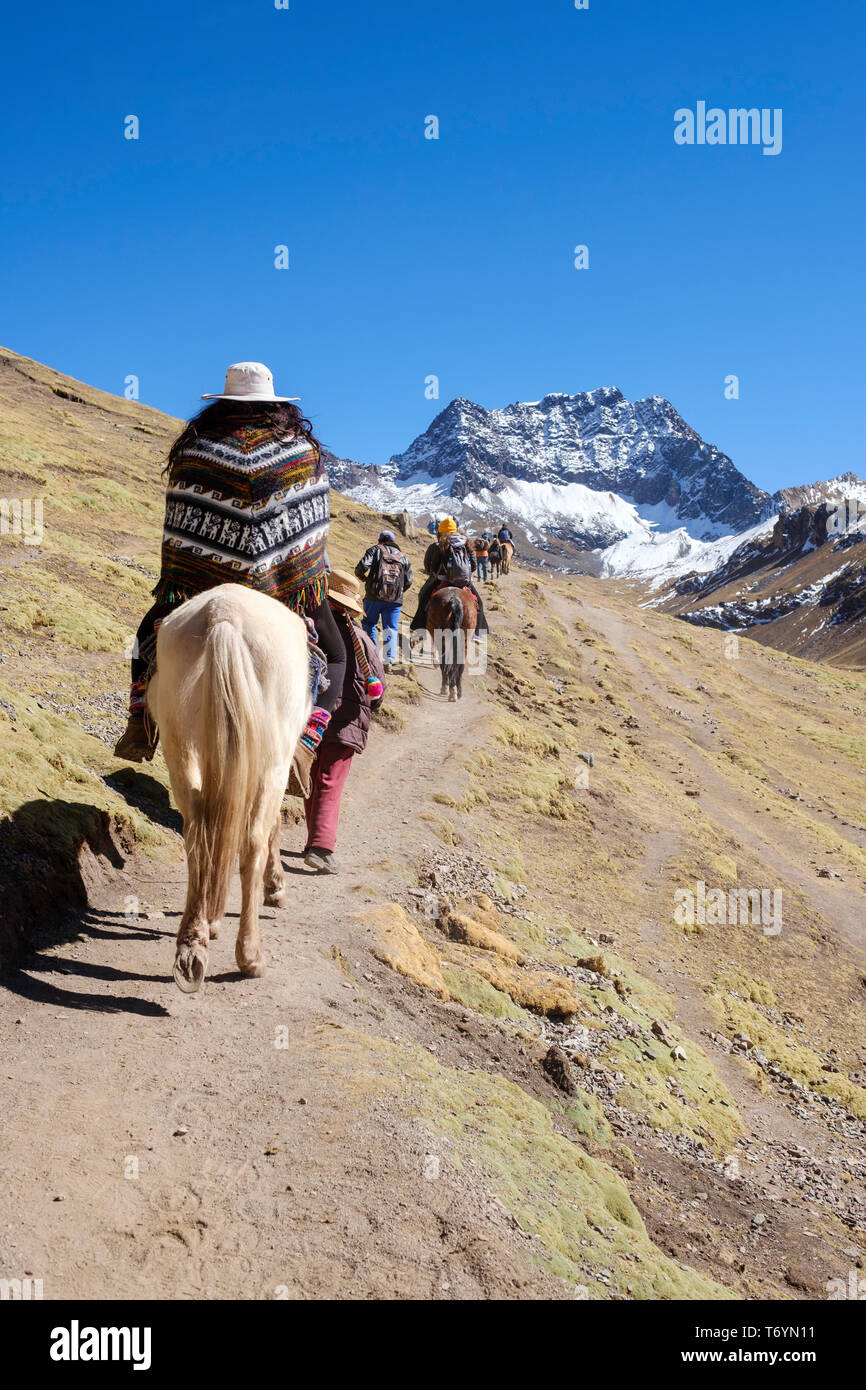 Tourists go hiking in the breathtaking Rainbow Mountain on a day trip in Los Andes of Peru Stock Photo