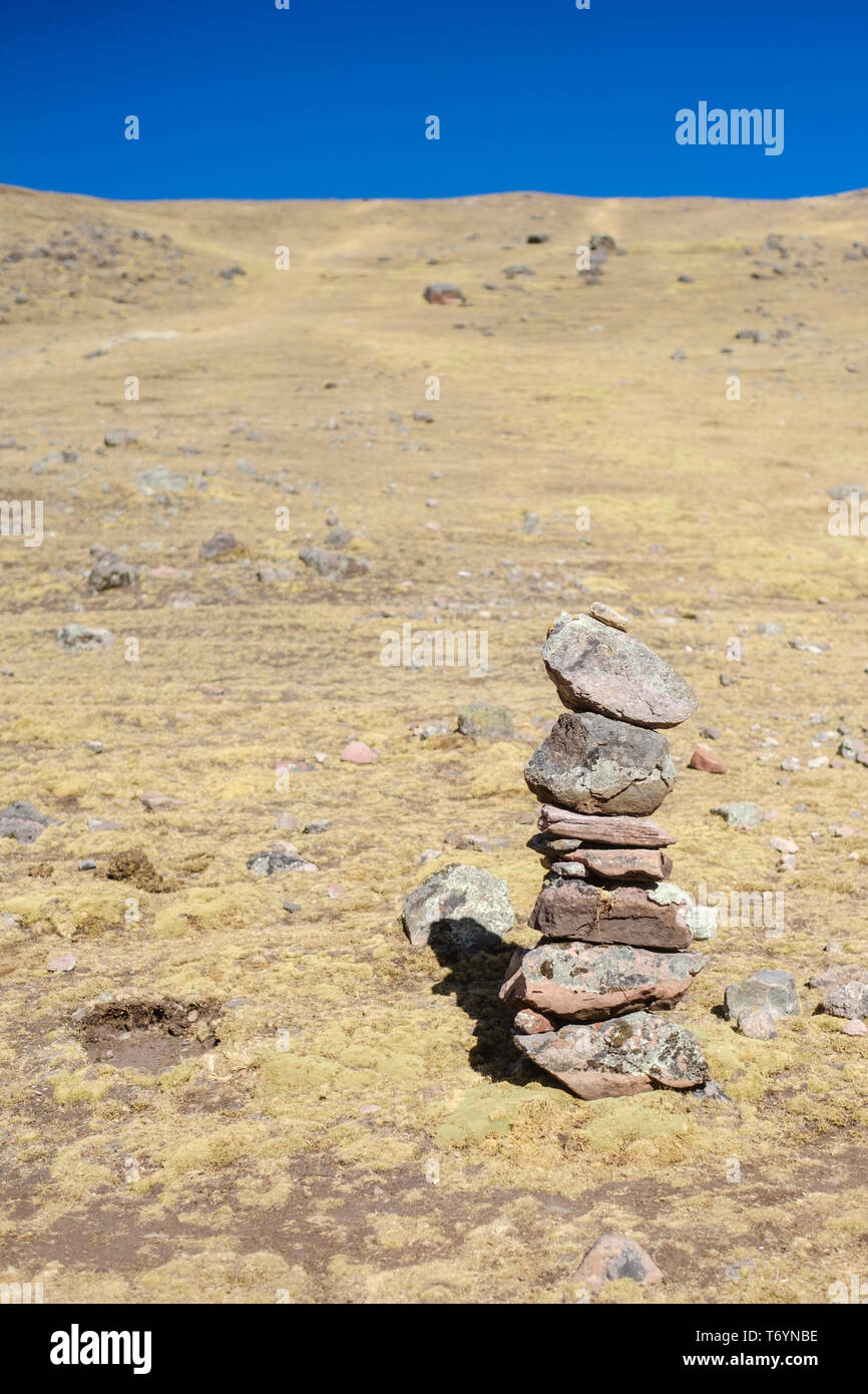 Human made stacked stones seen on the way to the Rainbow Mountain in Los Andes of Peru Stock Photo