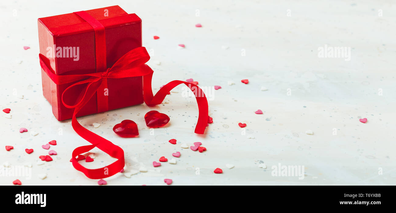 Gift box with red bow ribbon and heart Stock Photo - Alamy