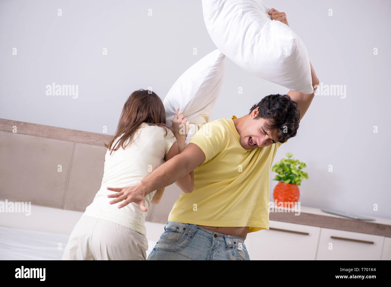 Wife and husband having pillow fight in bedroom Stock Photo Alamy