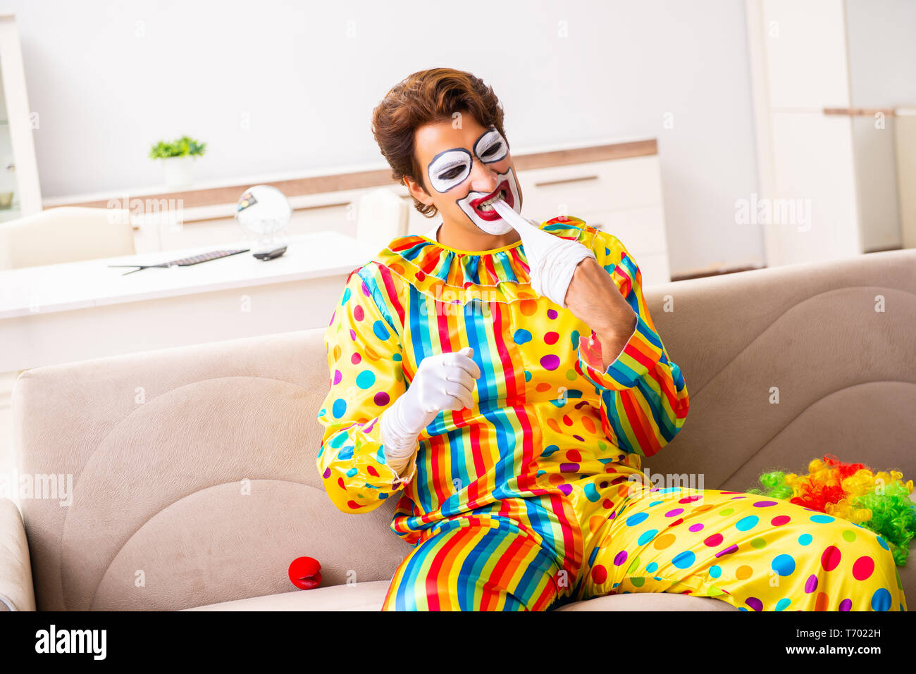 Male clown preparing for perfomance at home Stock Photo