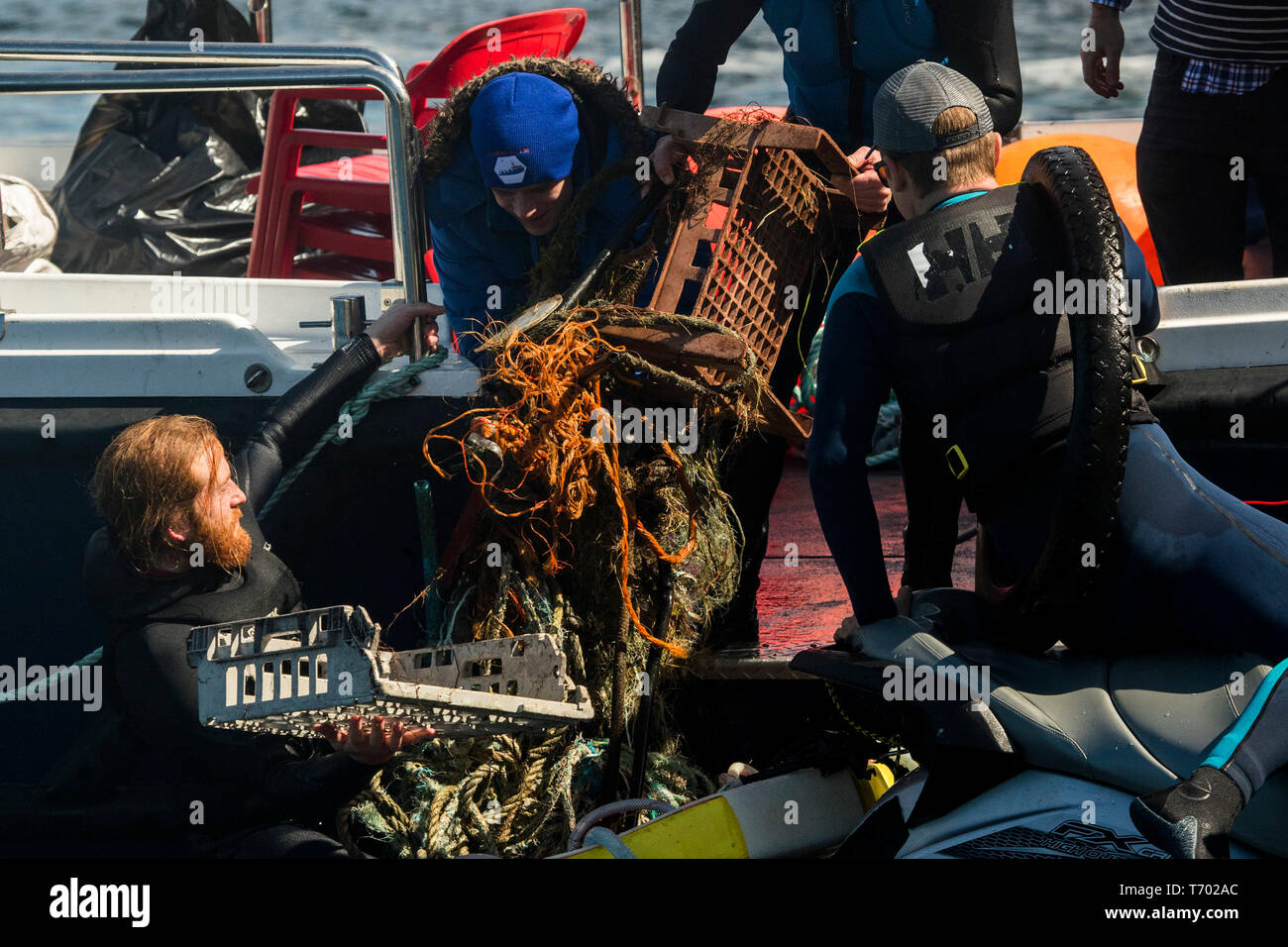 Volunteers load rubbish onto a boat during a litter pick around the