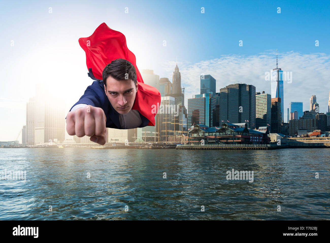 Superhero businessman flying over the city Stock Photo