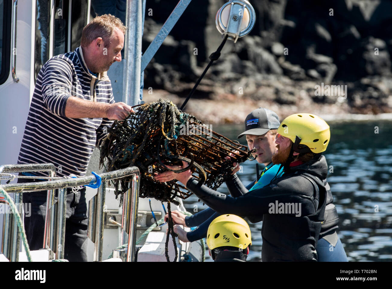 Volunteers load rubbish onto a boat during a litter pick around the