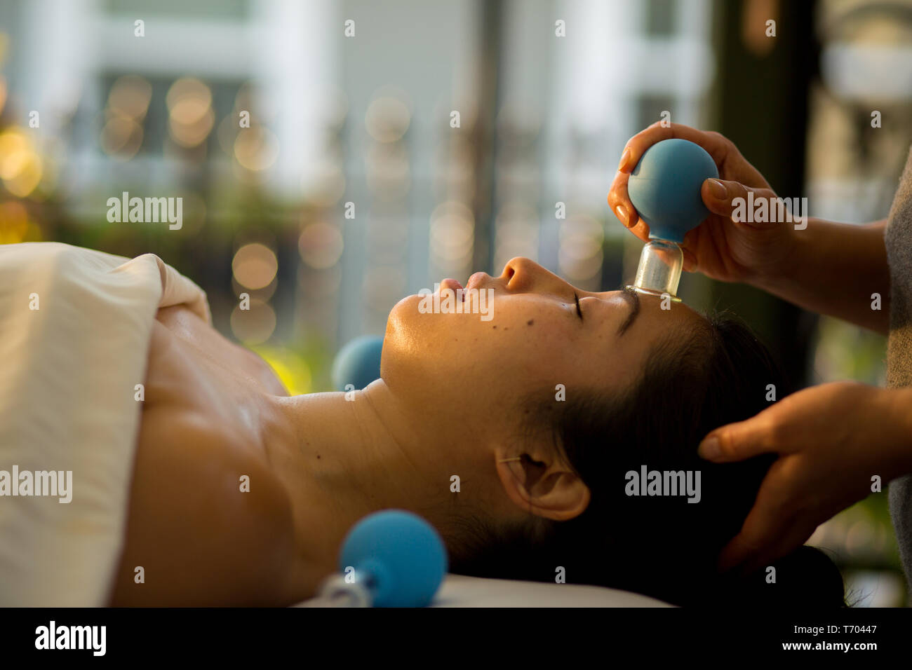 Young Woman receives facial cupping massage facial rejuvenation