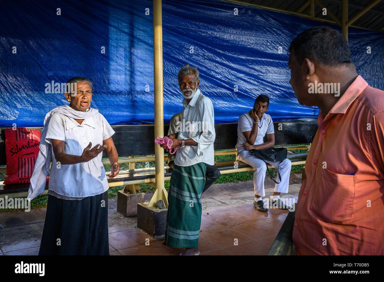 Verbal exchange between a woman and a man at the bus station, Kandy, Sri Lanka Stock Photo