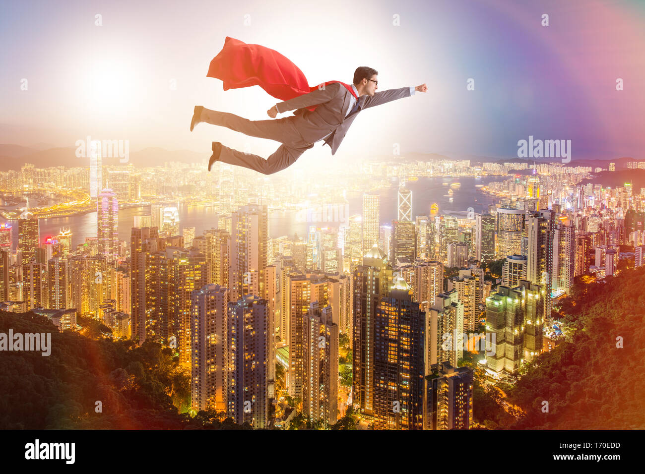 Superhero businessman flying over the city Stock Photo