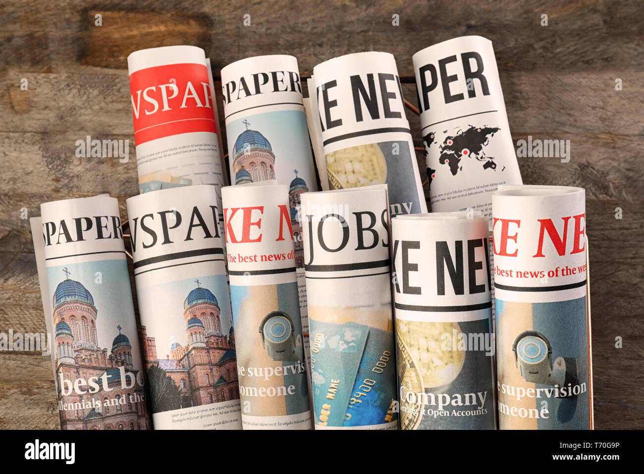 Rolled newspapers on wooden background Stock Photo