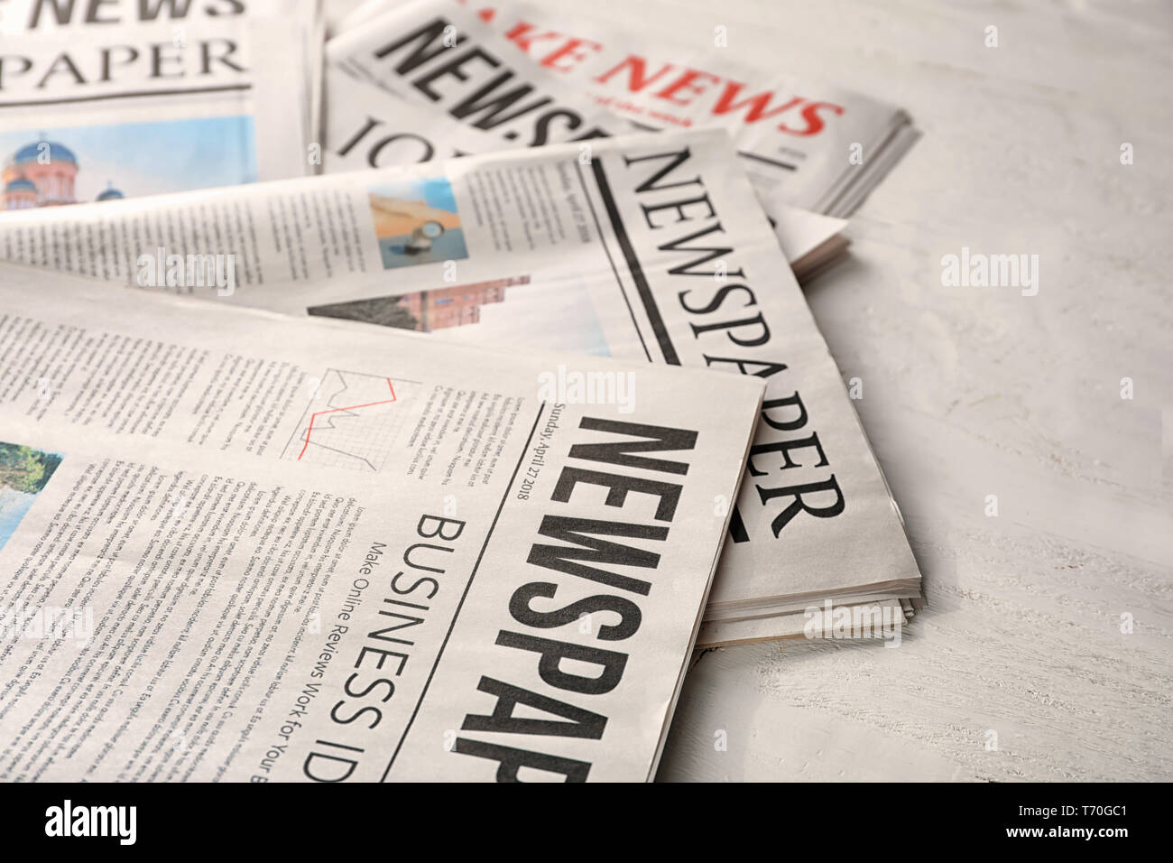 Newspapers on white wooden background Stock Photo