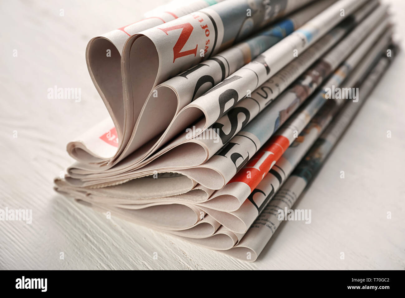 Newspapers on white wooden background Stock Photo