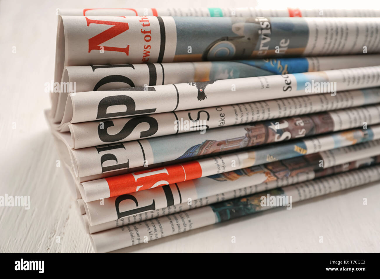 Newspapers on white wooden background Stock Photo