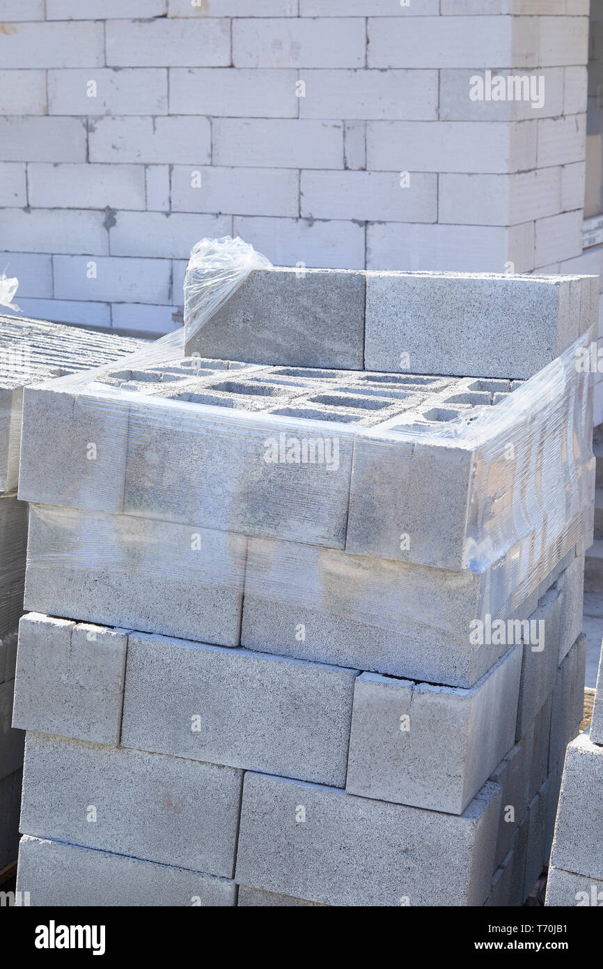 Concrete block bricks in stack for wall construction. Concrete block, cinder blocks, breeze blocks, hollow blocks, Besser blocks or Besser bricks wall Stock Photo