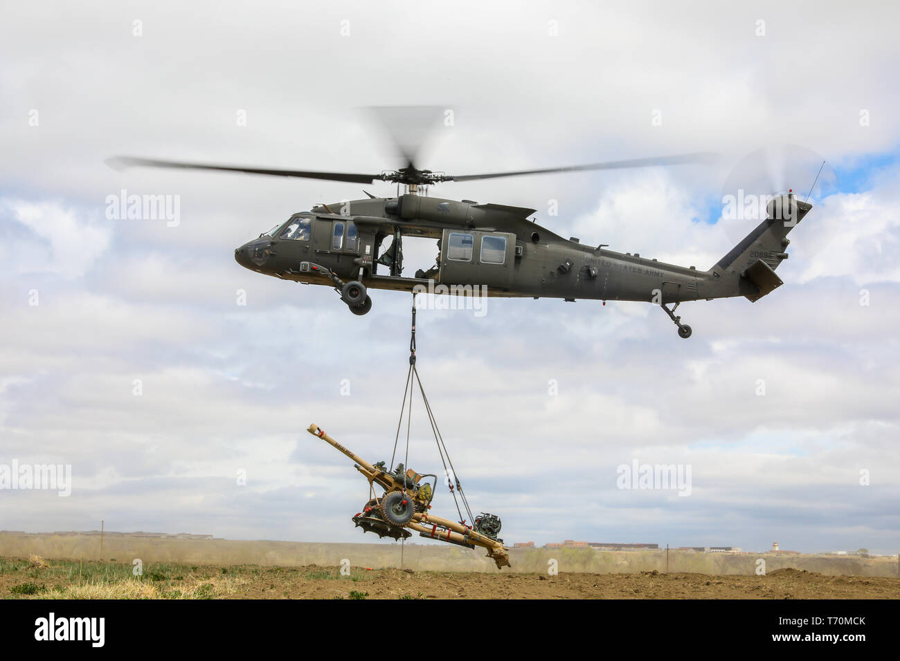 A UH-60 Black Hawk, piloted by members of the 4th Combat Aviation Brigade, 4th Infantry Division, picks up a M119 Howitzer, May 2, 2019, during air assault training with Soldiers Bravo Battery, 2nd Battalion, 77th Field Artillery Regiment, 2nd Infantry Brigade Combat Team, 4th Inf. Div., on Fort Carson, Colorado. (U.S. Army photo by Staff Sgt. Neysa Canfield) Stock Photo
