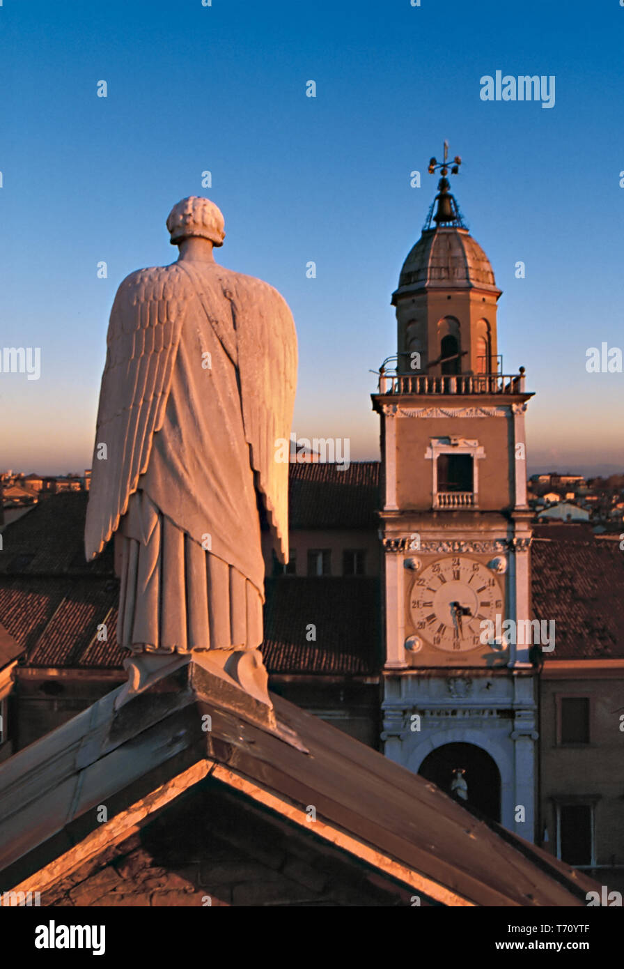 Modena: statua dell'Arcangelo Gabriele sul timpano del transetto centrale del Duomo e, sullo sfondo, la Torre Civica.  [ENG] Modena: statue of Archang Stock Photo