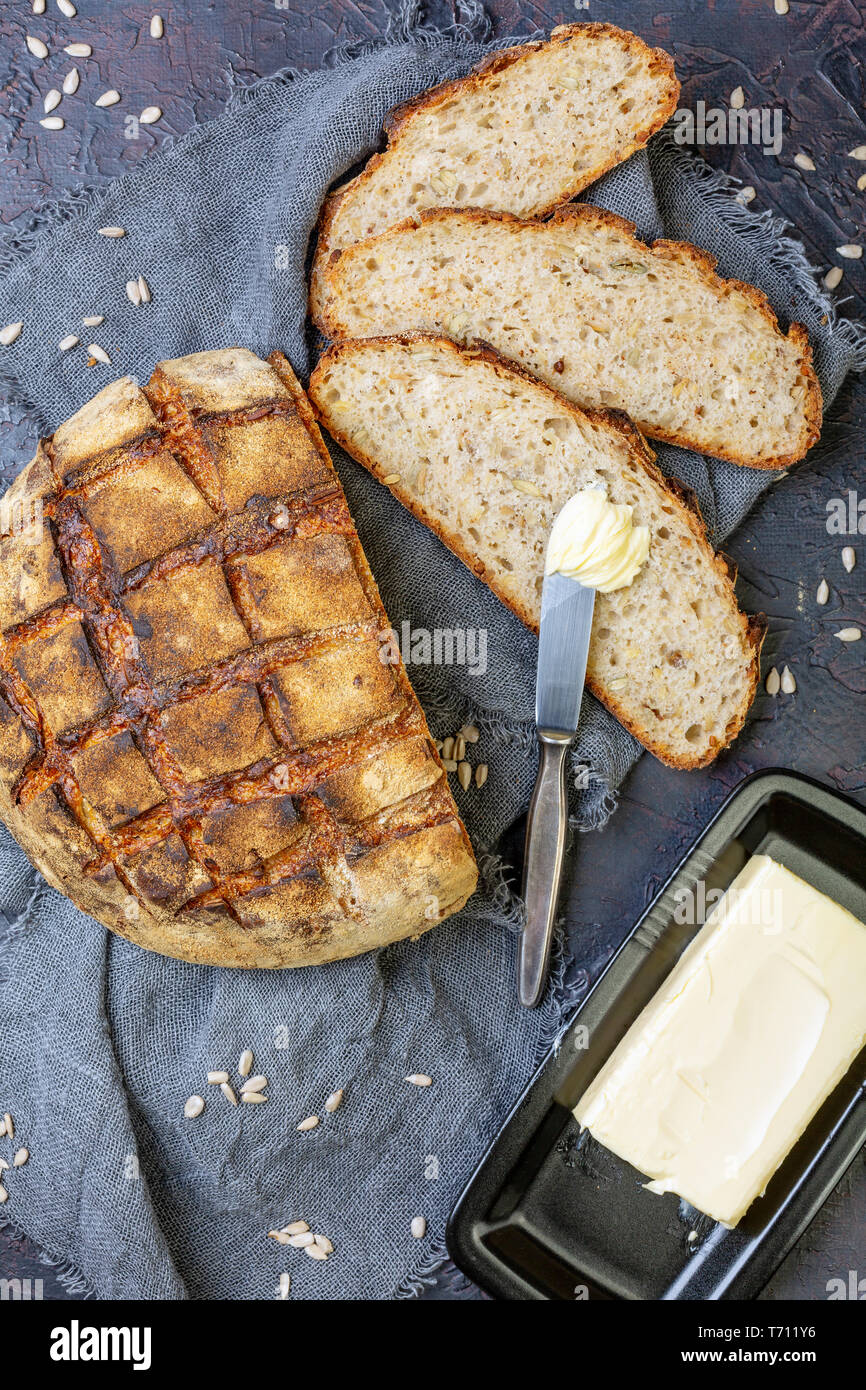 Artisanal rustic bread sliced and butter. Stock Photo