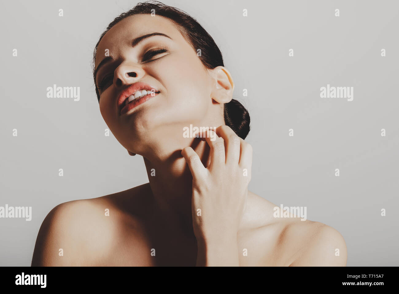 Young woman scratching her itchy skin on neck. Atopic dermatitis. Stock Photo