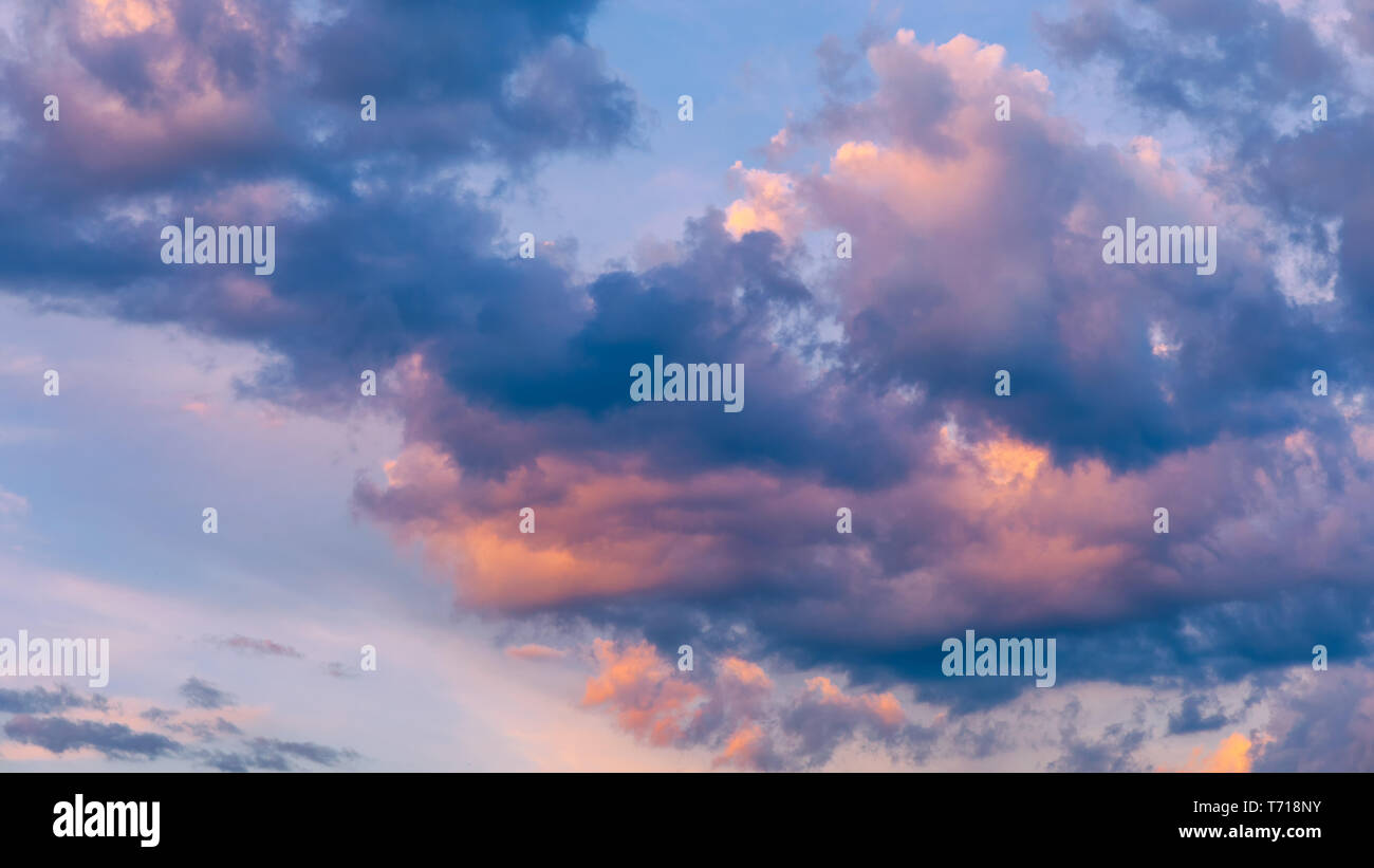 Beautiful sunset sky above clouds with dramatic light. Sunset sky for background, sunrise sky and clouds. Bright orange and blue sky and light of the  Stock Photo